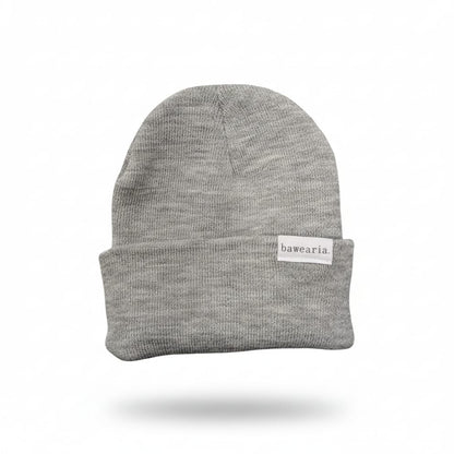 Produktansicht einer grauen bawearia Strickmütze mit weißem Logo-Label am Umschlag.