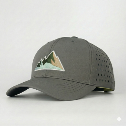 Nahaufnahme einer grauen Outdoor-Cap mit aufgesticktem Berg-Motiv und perforierten Seitenteilen für Belüftung.