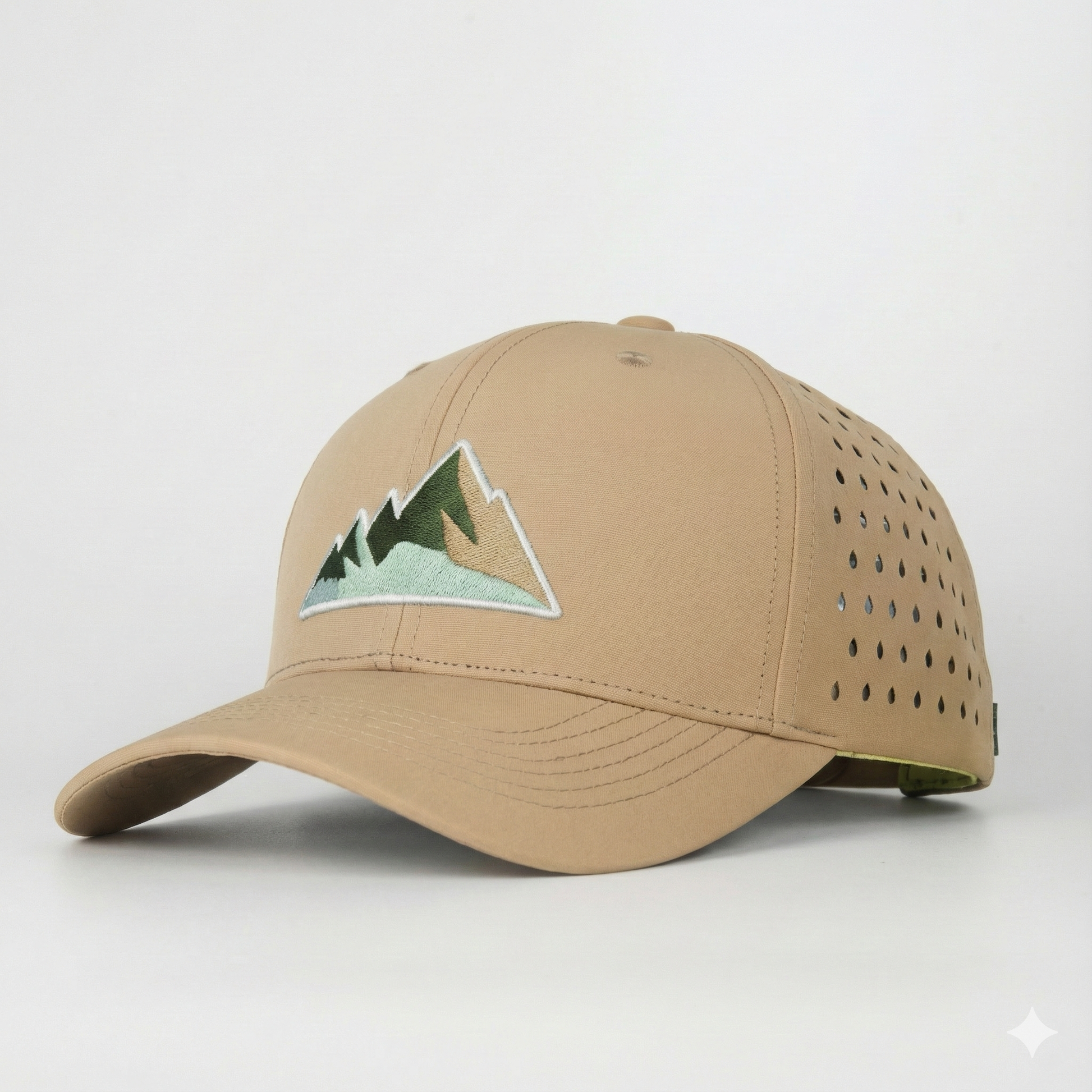 Seitliche Ansicht einer beigen Wander-Cap mit grün-braunem Berg-Motiv und atmungsaktivem Lochmuster.